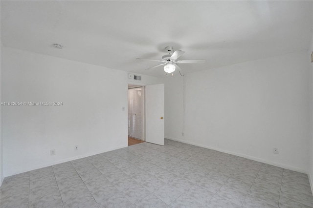 empty room with light tile patterned floors and ceiling fan