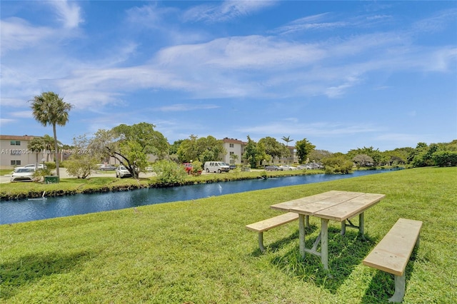 surrounding community featuring a water view and a lawn