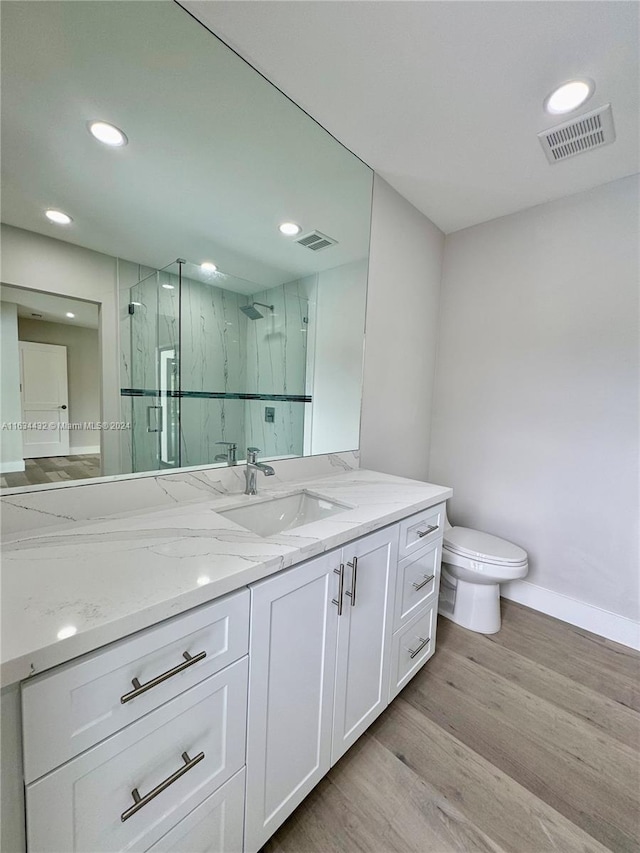 bathroom featuring wood-type flooring, toilet, and vanity