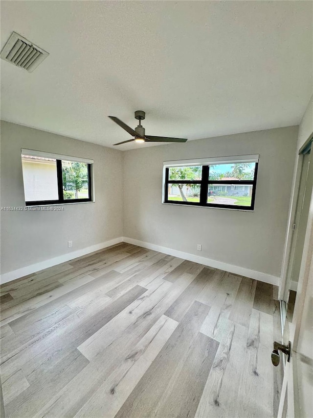 spare room featuring light hardwood / wood-style flooring and ceiling fan