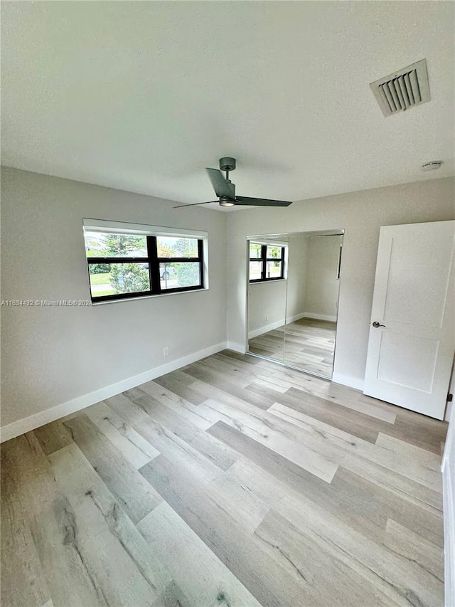 unfurnished bedroom featuring light hardwood / wood-style flooring and ceiling fan