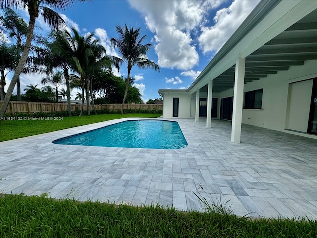 view of swimming pool featuring a patio and a lawn