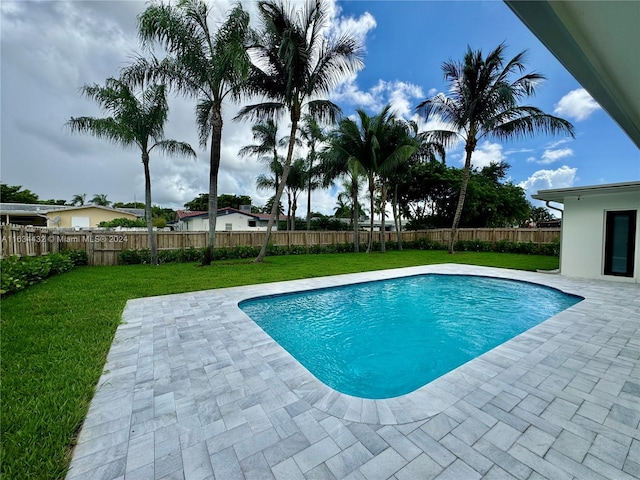 view of pool with a patio and a lawn