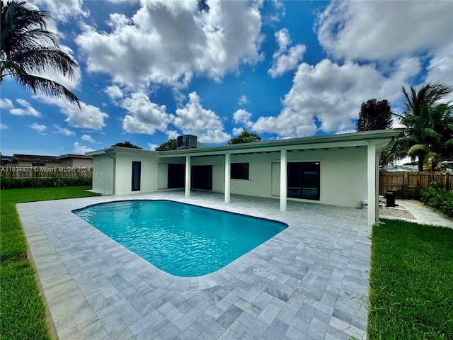 view of swimming pool featuring a patio and a yard