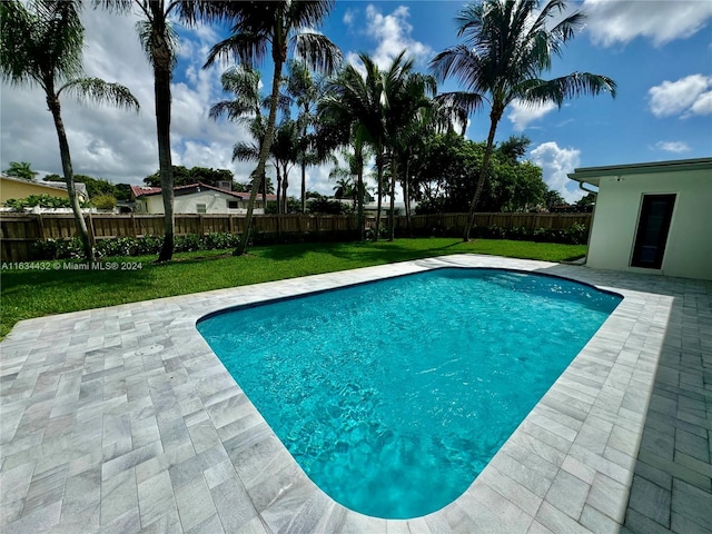 view of swimming pool featuring a patio and a lawn