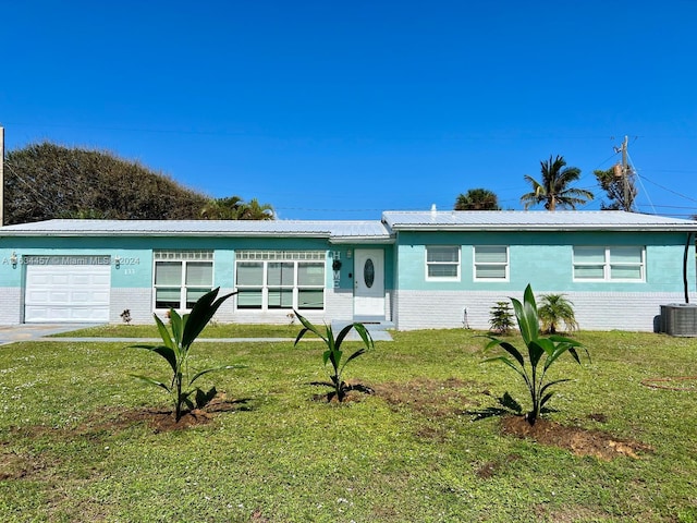 ranch-style home with cooling unit, a front lawn, and a garage