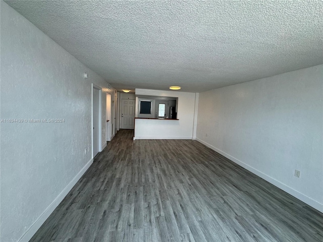 unfurnished living room featuring wood-type flooring and a textured ceiling