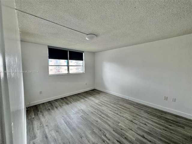 spare room with a textured ceiling and hardwood / wood-style flooring