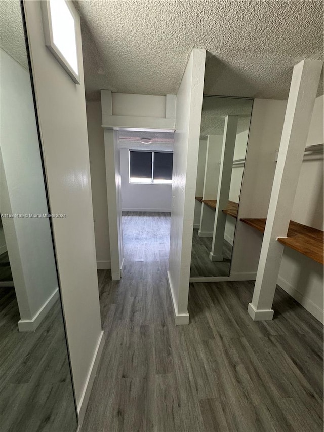 hallway featuring dark hardwood / wood-style floors and a textured ceiling