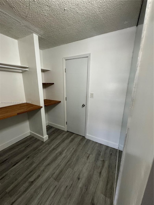 walk in closet with dark wood-type flooring