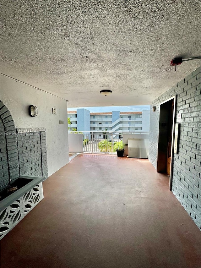 interior space with brick wall and a textured ceiling