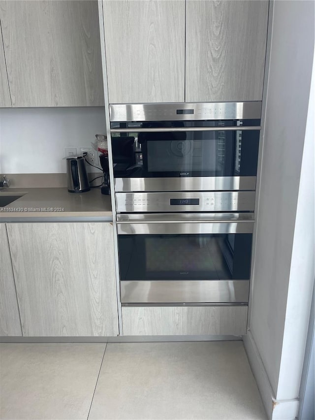 kitchen with sink, light brown cabinets, and double oven