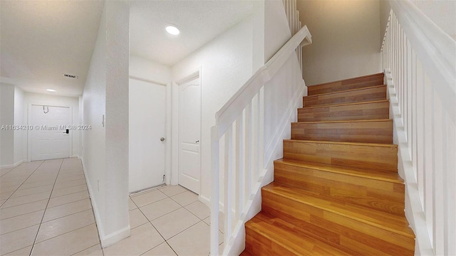 stairway with light tile patterned floors