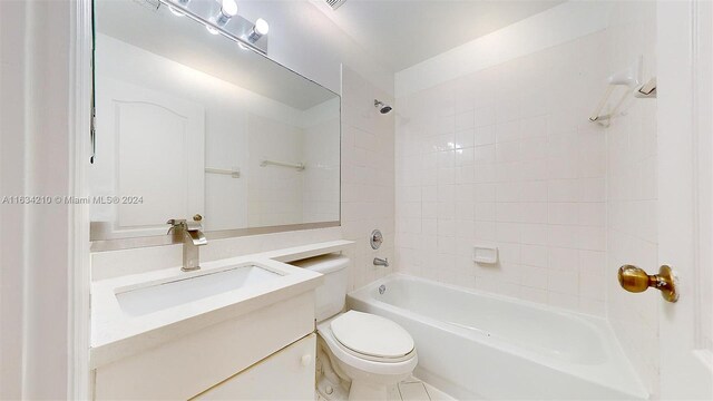 full bathroom with vanity, tiled shower / bath, tile patterned floors, and toilet