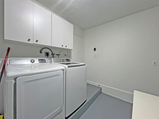 laundry area with separate washer and dryer, cabinets, and a textured ceiling