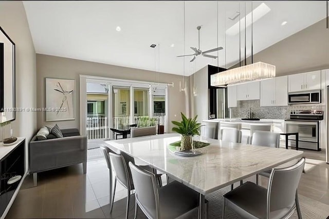 dining room with a high ceiling and a ceiling fan