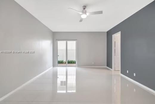 empty room with a ceiling fan and baseboards