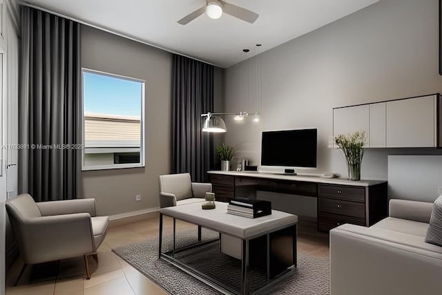 office space featuring baseboards, ceiling fan, and a towering ceiling