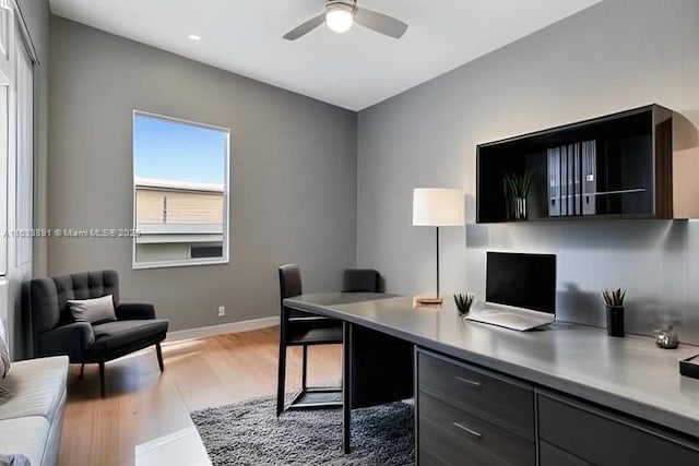 home office featuring baseboards, light wood-style floors, and a ceiling fan