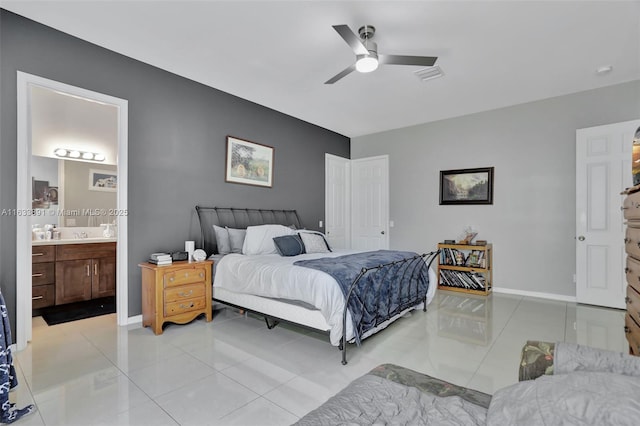 tiled bedroom featuring ceiling fan and ensuite bath