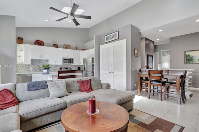 tiled living room featuring high vaulted ceiling and ceiling fan