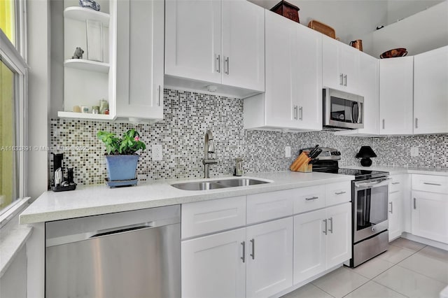 kitchen with white cabinetry, sink, light tile patterned floors, and stainless steel appliances