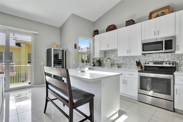 kitchen featuring a sink, decorative backsplash, light tile patterned floors, and stainless steel appliances