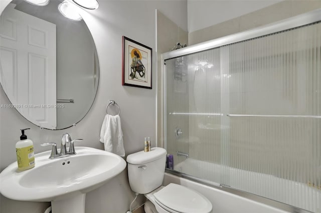 full bathroom featuring toilet, sink, and combined bath / shower with glass door