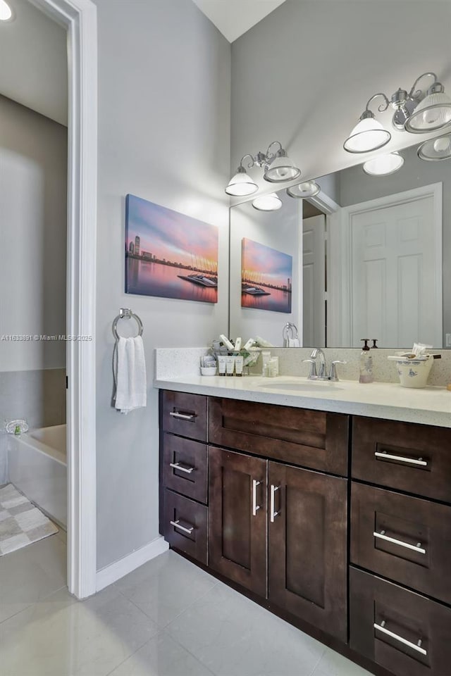 bathroom featuring tile patterned flooring, vanity, and a bath