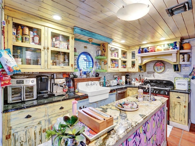 kitchen with dark stone countertops, wood ceiling, light tile patterned floors, and stainless steel dishwasher