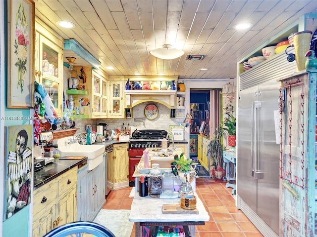 kitchen with tasteful backsplash, range, sink, light tile patterned floors, and wood ceiling