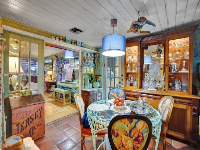 dining room with tile patterned flooring and wood ceiling