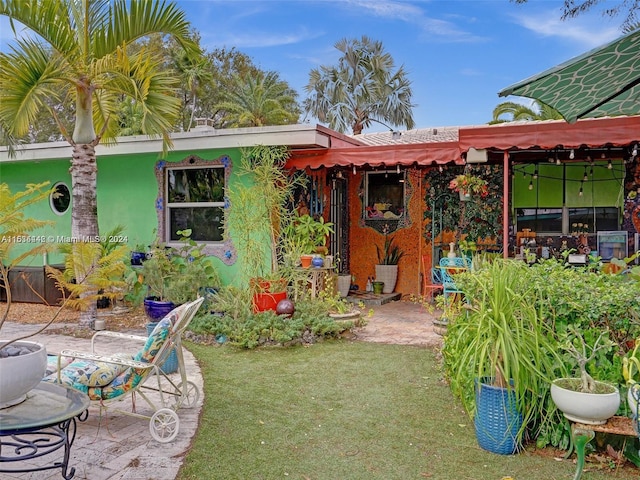 rear view of house featuring a patio and a lawn