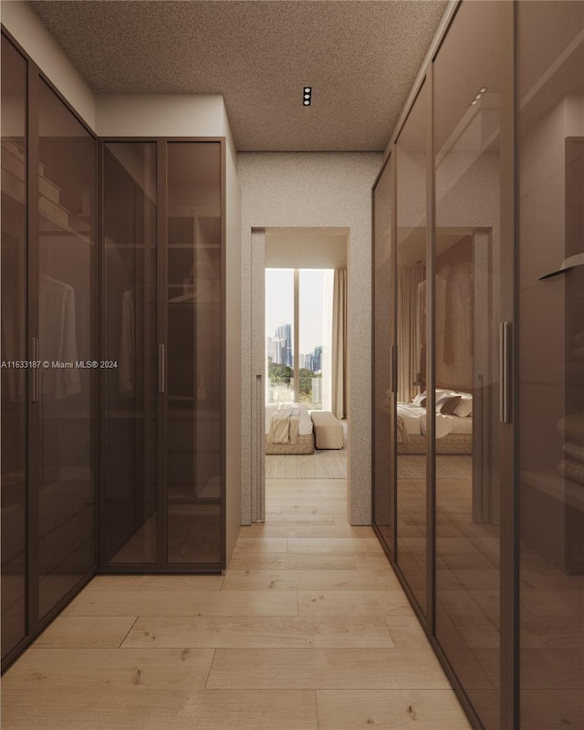 hallway featuring a textured ceiling and light hardwood / wood-style flooring