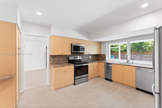 kitchen featuring light brown cabinetry, sink, stainless steel appliances, and backsplash