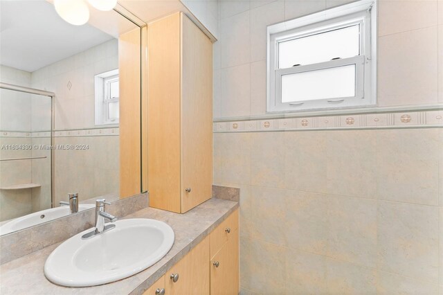 bathroom featuring vanity and tile walls