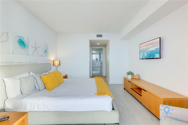 bedroom featuring light hardwood / wood-style flooring and connected bathroom