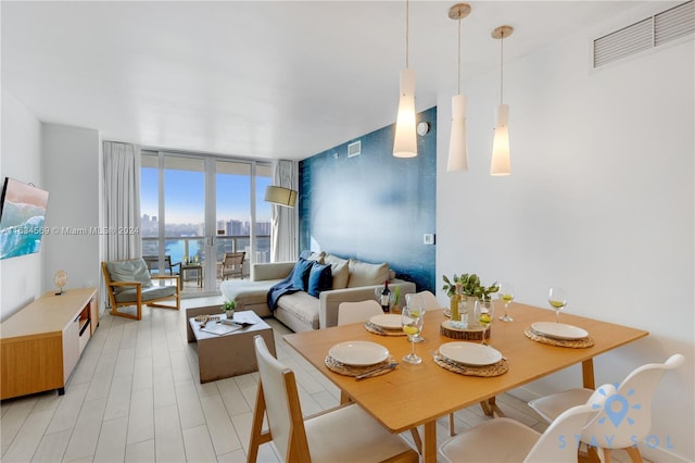 dining space with a water view and expansive windows