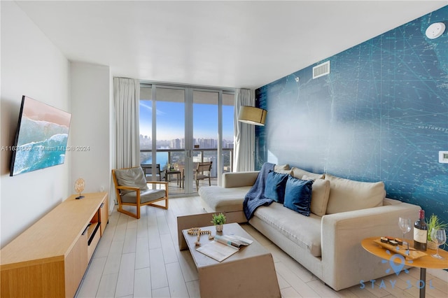 living room featuring a water view and a wall of windows