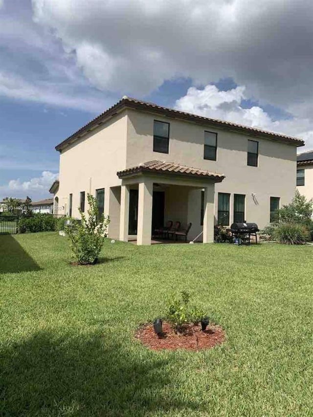 rear view of house featuring a patio and a yard