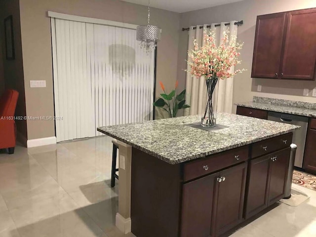 kitchen with dishwashing machine, a kitchen island, light stone counters, and light tile patterned floors