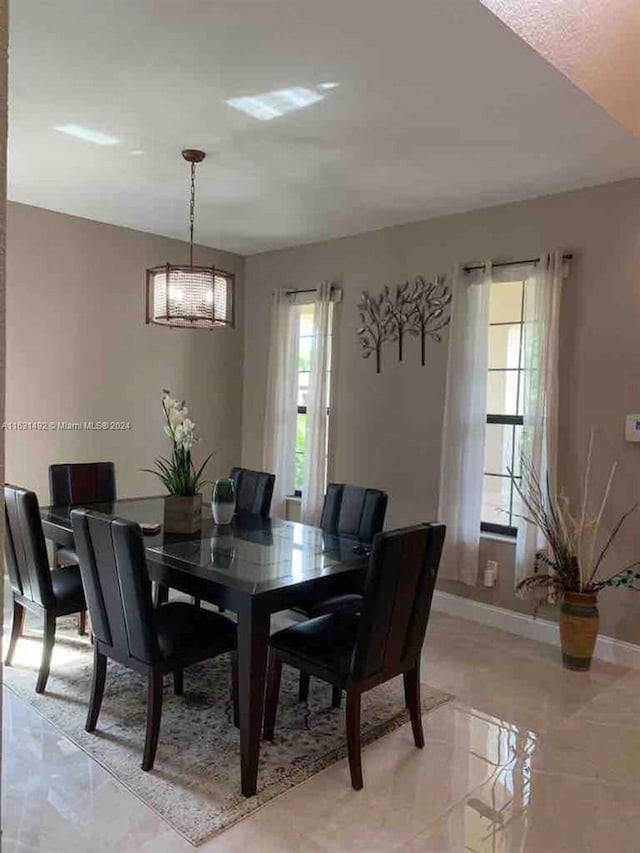 tiled dining room featuring a notable chandelier