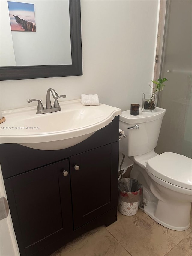 bathroom featuring vanity, toilet, and tile patterned flooring