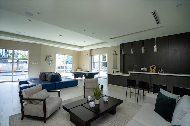 living room featuring a wealth of natural light and a raised ceiling