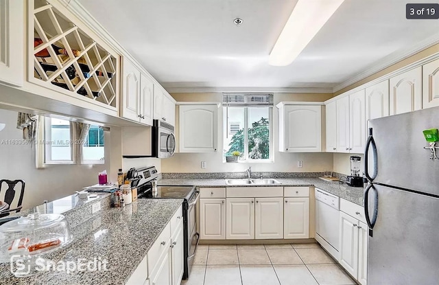 kitchen featuring appliances with stainless steel finishes, a sink, white cabinets, light tile patterned flooring, and crown molding