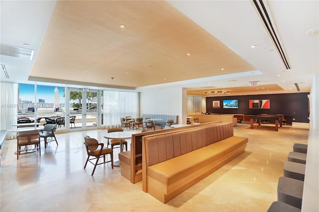 interior space with french doors, a tray ceiling, and floor to ceiling windows