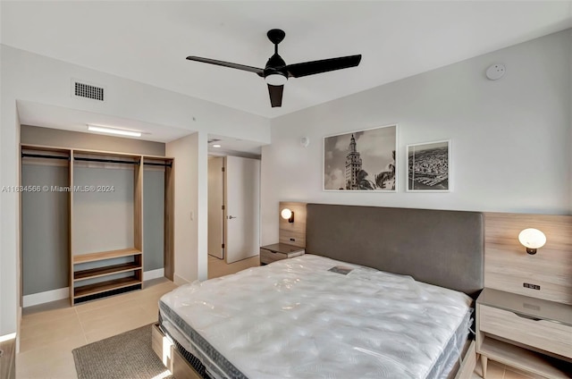 tiled bedroom featuring ceiling fan and a closet