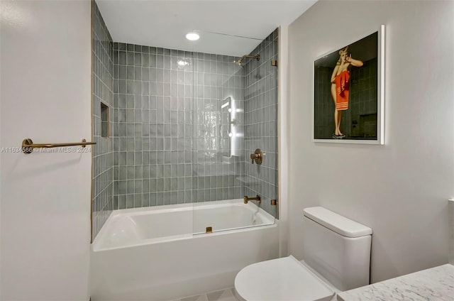 bathroom with toilet and tiled shower / bath