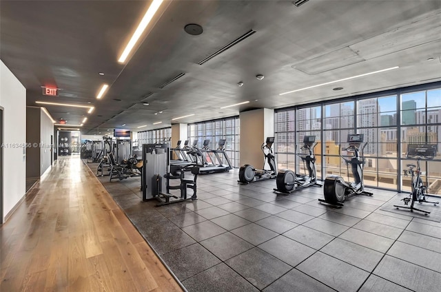 workout area featuring hardwood / wood-style floors and a wall of windows