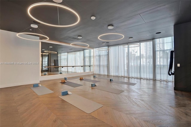 gym featuring a wall of windows, parquet flooring, and a wealth of natural light